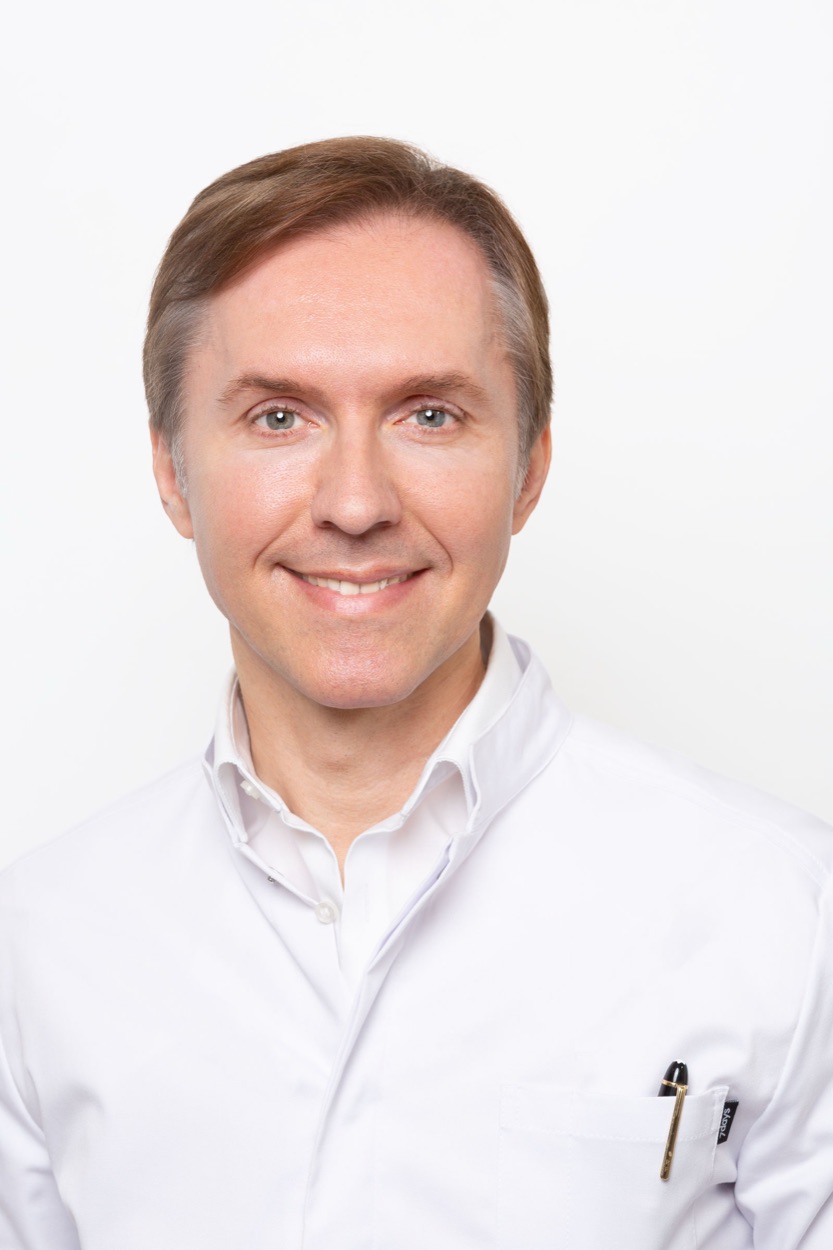 Porträt von Dr. med. Denis Alekseev im weißen Arztkittel