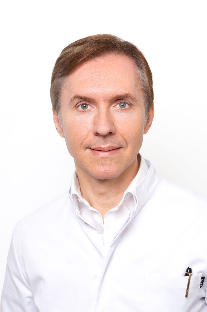 Porträt von Dr. med. Denis Alekseev im weißen Arztkittel